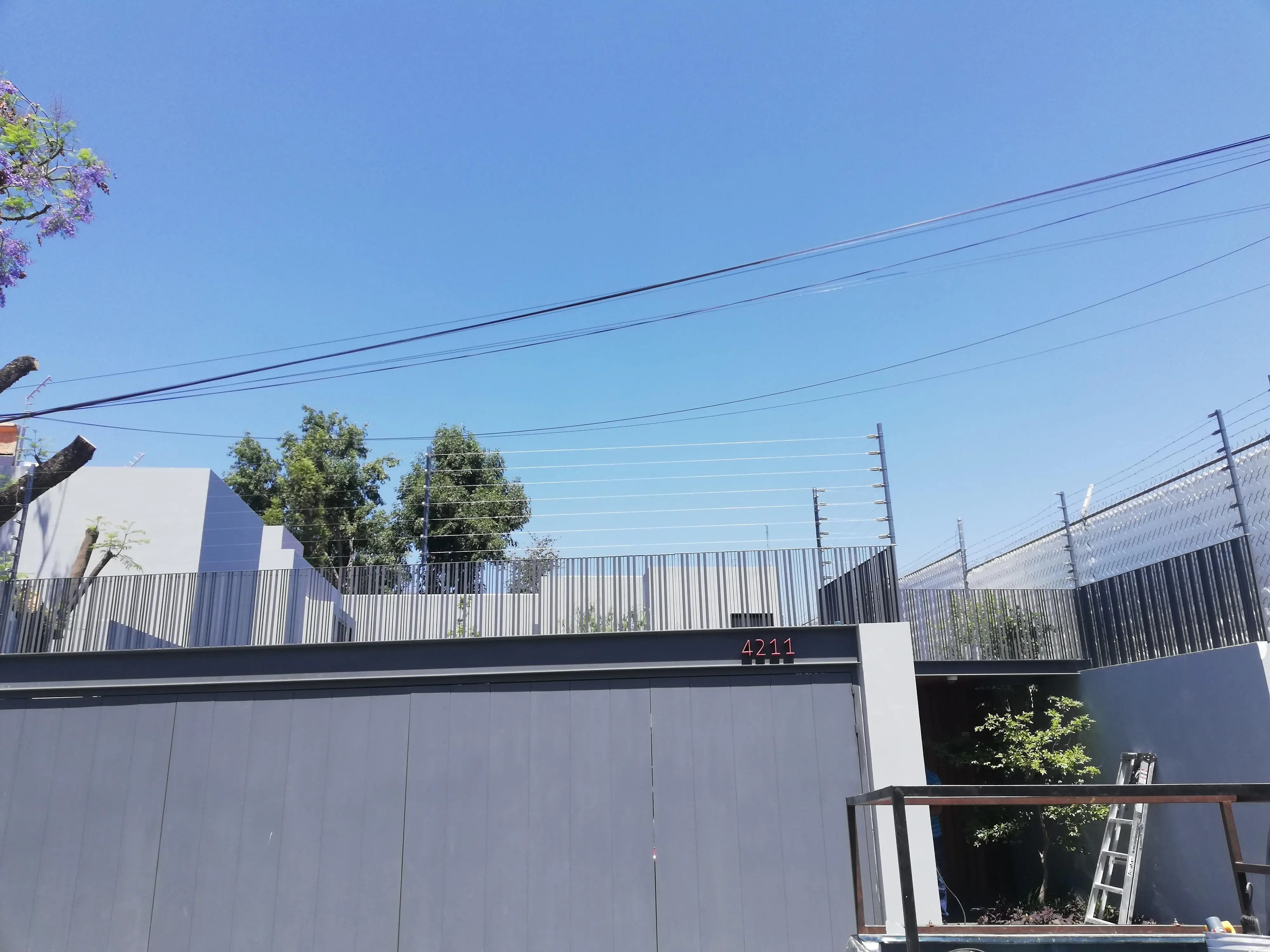 Cerca electrificada con postes ángulo y alambre galvanizado en barda industrial, Tlaquepaque Jalisco